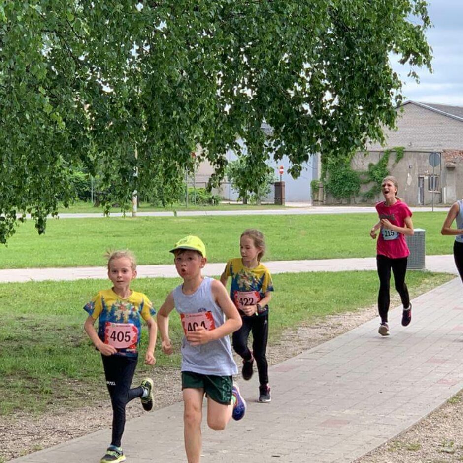 Četri bērni skrien pa trotuāru